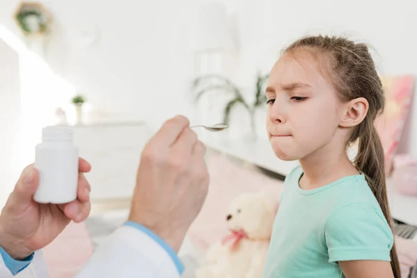 Schattig Klein Meisje Kijken Met Tegenzin Naar Geneeskunde Lepel Vastgehouden — Stockfoto