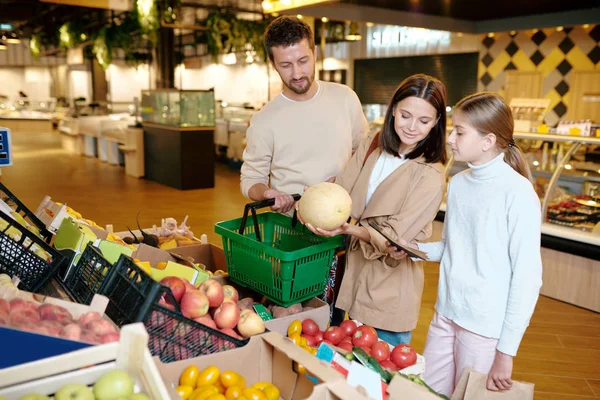 Fiatal Férje Lányuk Dinnyét Választják Szupermarketben Miközben Friss Gyümölcsökkel Állnak — Stock Fotó