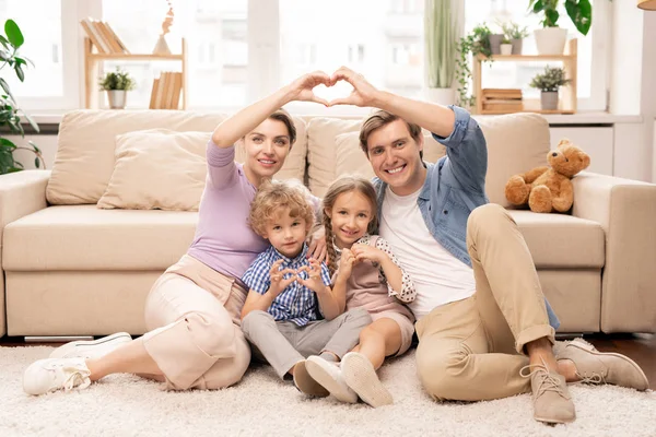 Padres Felices Dos Adorables Hermanos Sentados Suelo Frente Cámara Haciendo — Foto de Stock