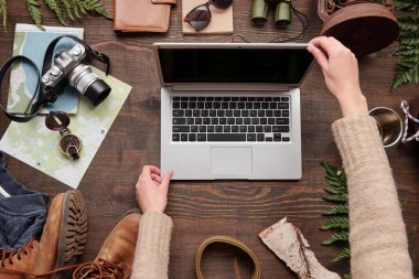 İnternet 'te yürüyüş yeri aramaya hazırlanırken süveter giyen tanınmayan bir kadının üstü açık dizüstü bilgisayarı, düz bir şekilde yatıyordu.