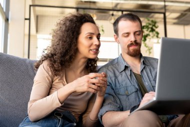 Lüks restoranın genç sahipleri ya da rahat bir kafe koltukta oturup iç mekan ya da aksesuarlar için online fikirleri tartışırlar.