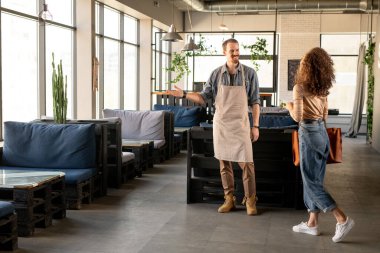 Mutlu genç adam heyecanlı karısına bakıyor. İkisi de kendi restoranlarını açmaktan zevk alıyor.