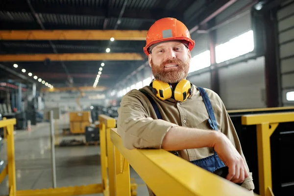 Retrato Trabalhador Masculino Positivo Hardhat Laranja Apoiando Grades Metal Loja — Fotografia de Stock