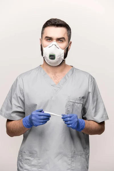 病気の患者との作業中に温度計を保持しながら あなたを見て均一な 保護手袋やマスクの現代の医師 — ストック写真