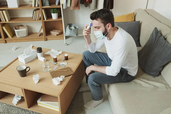 Jeune Homme Malade Masque Médical Mesurant Température Son Corps Assis — Photo