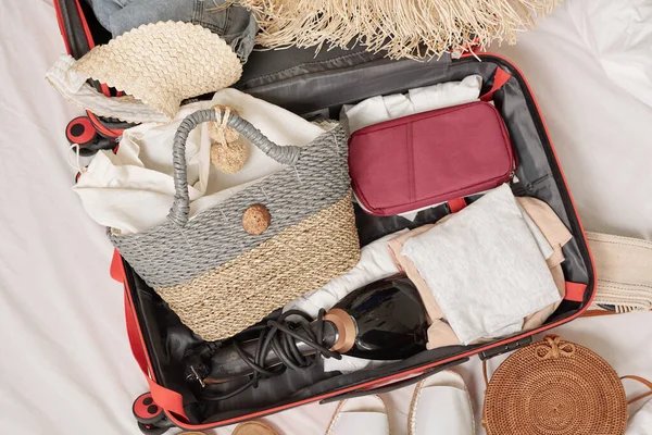 ベッドの上のスーツケースに詰め込まれた女性のものの上のビュー 夏休み前の準備 — ストック写真