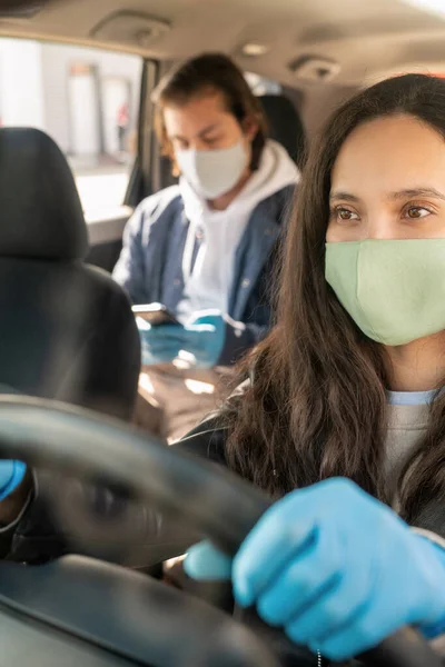 Νεαρή Γυναίκα Οδηγός Ταξί Προστατευτικά Γάντια Και Μάσκα Κοιτάζοντας Προς — Φωτογραφία Αρχείου