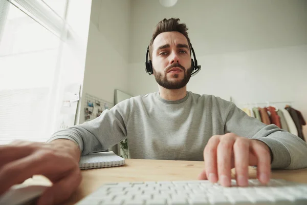 Giovane Operatore Serio Con Auricolare Guardando Display Portatile Mentre Seduto — Foto Stock