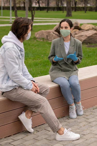 보호용 장갑을 마스크를 공원에 친구에게 무엇인가를 설명하는 — 스톡 사진