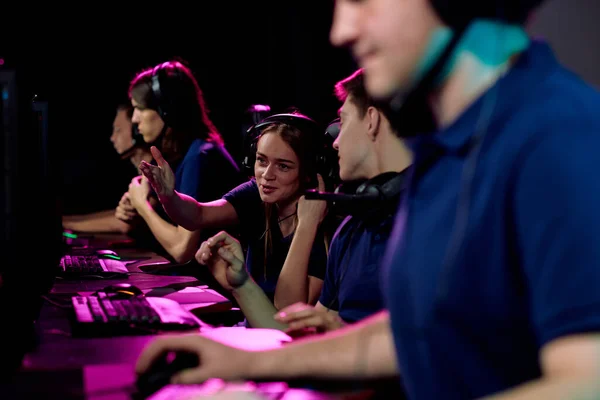 快乐的女孩一边指指点着她朋友的电脑屏幕 一边在比赛准备过程中就网络游戏提供建议 — 图库照片