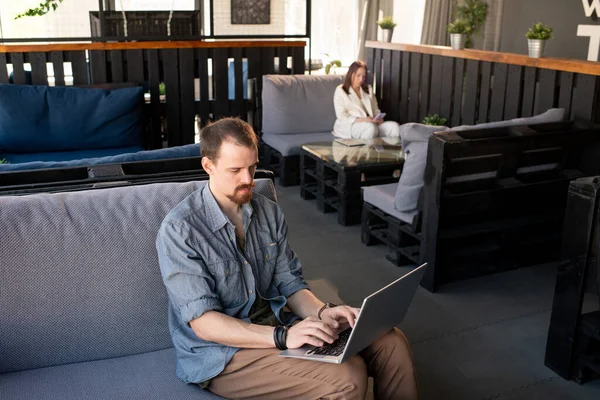 Drukke Jongeman Casualwear Zittend Bank Met Laptop Zijn Knieën Surfen — Stockfoto