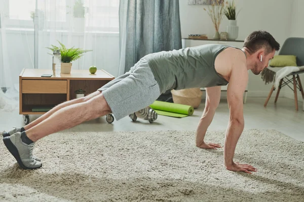 Joven Ropa Deportiva Auriculares Haciendo Flexiones Suelo Sala Estar Casa — Foto de Stock