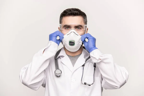 眼鏡を身につけた現代の若手臨床医が病院で患者さんと仕事をしながら呼吸器を顔につけています — ストック写真