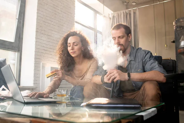 Joven Contemporáneo Fumando Cigarrillo Electrónico Mientras Está Sentado Junto Esposa — Foto de Stock