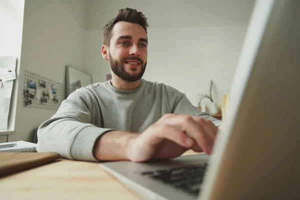 Pebisnis Muda Tersenyum Melihat Tampilan Laptop Sambil Bekerja Jarak Jauh — Stok Foto