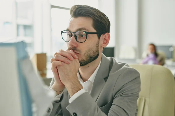 Geconcentreerde Jonge Bebaarde Zakenman Leunend Handen Kijkend Naar Computer Monitor — Stockfoto