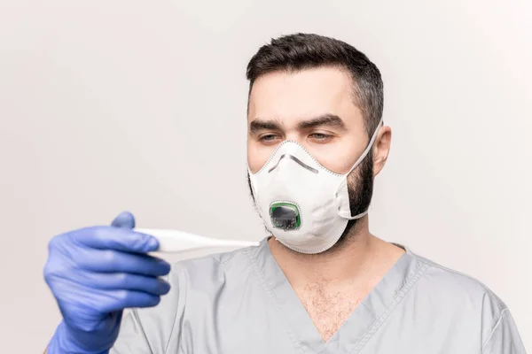 Cabeça Ombros Médico Uniforme Luvas Respirador Olhando Para Termômetro Enquanto — Fotografia de Stock