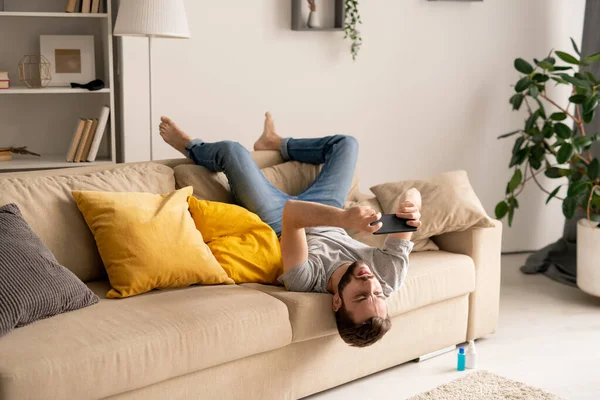 Hombre Barbudo Joven Sentado Boca Abajo Sofá Sala Estar Jugando — Foto de Stock