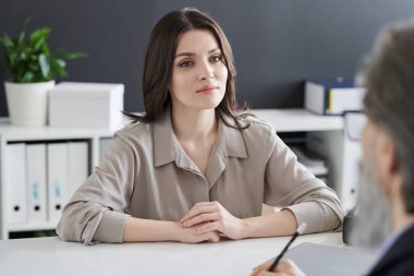 Formalite içinde genç bir kadın psikolojik sorunları hakkında danışmanıyla konuşurken onu dinliyor.