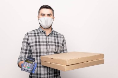 Kafedeki genç kurye elinde iki büyük karton kutu ve ödeme makinesiyle pizza siparişi verirken...