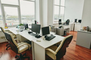 Masaüstü bilgisayarları yan yana yerleştirilmiş boş modern ofis Coronavirus karantina konsepti