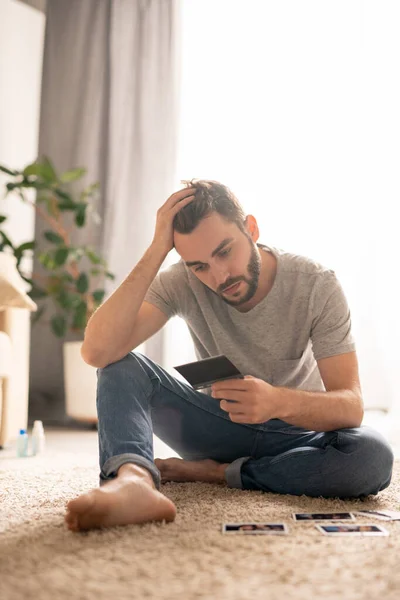 Jeune Homme Barbu Solitaire Jeans Assis Sur Tapis Tenant Tête — Photo