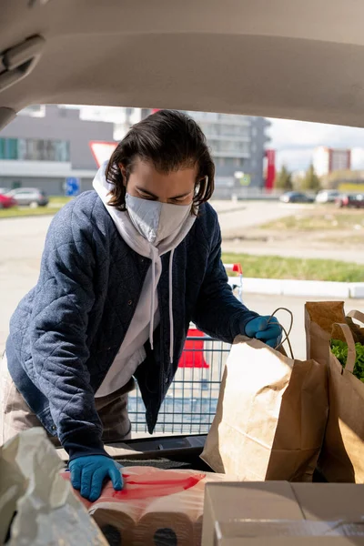 Νεαρός Βάζοντας Χαρτοσακούλες Φρέσκα Τρόφιμα Και Συσκευασία Χαρτί Τουαλέτας Στο — Φωτογραφία Αρχείου