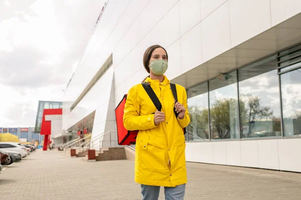 Kurir Muda Yang Memakai Jaket Kuning Dan Topeng Pelindung Berjalan — Stok Foto