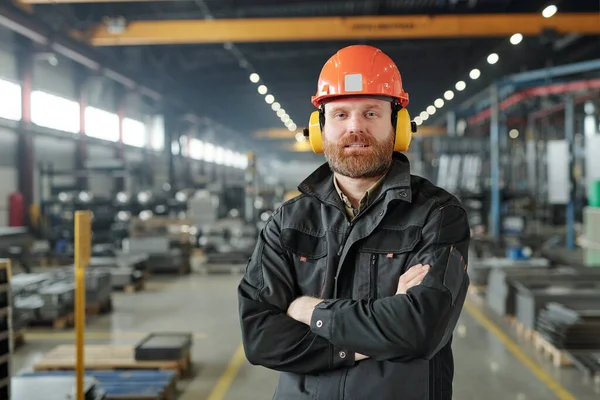 当代工业厂房车间内戴护耳镜 戴硬礼帽 满脸胡须的工厂工人的画像 — 图库照片