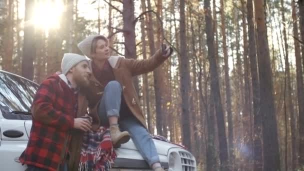Jong Blank Paar Beanies Ontspannen Tijdens Autorit Poseren Voor Smartphone — Stockvideo