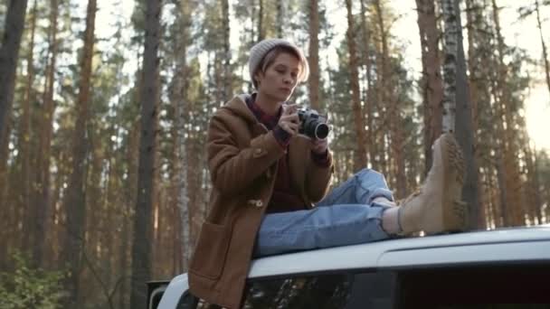 베니를 자동차 지붕에 캅카스 여성은 가을에 자연의 사진을 카메라를 — 비디오