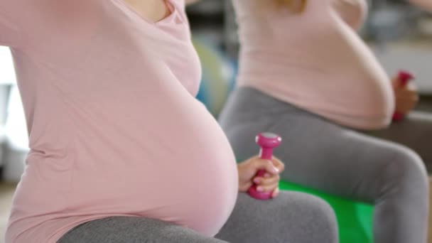 安定したボールに座っている妊婦のショットを傾け フィットネスクラスでサイドストレッチ演習を実行 — ストック動画