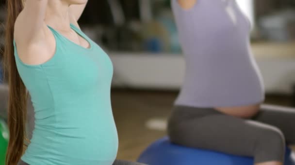 サイドビュー傾斜アップショットのリラックス妊娠中の女性の安定性ボールに座って ヨガの手の位置を練習し 呼吸法を行う — ストック動画
