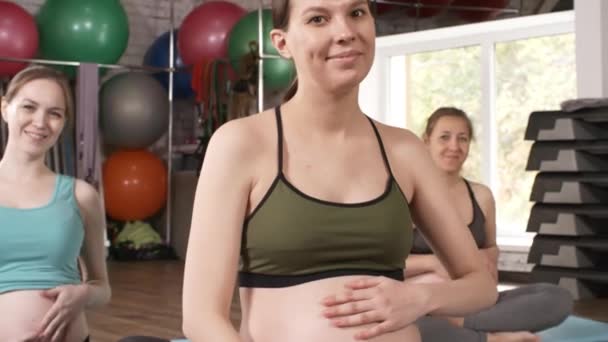 Mediana Toma Tres Mujeres Embarazadas Sentadas Colchonetas Yoga Gimnasio Acariciando — Vídeos de Stock