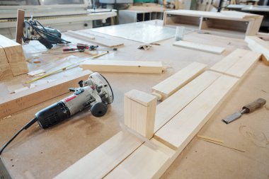 Modern mobilya fabrikası işçilerinden oluşan geniş bir tezgah. Birkaç elektrikli el aletleri ve ahşap işleme için keski.
