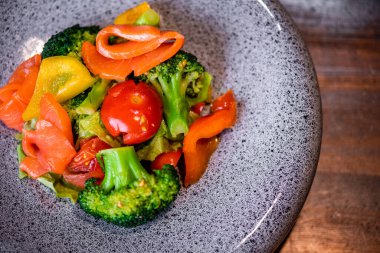 Yaz salatasının üstünde, tabakta somon dilimleri ve taş yapısıyla.