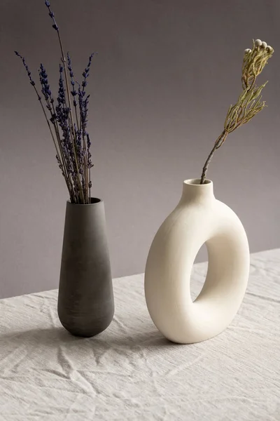 用两个陶瓷手工制作的花瓶和干薰衣草及野花组成的静物画 放在桌上 上面铺着白布 — 图库照片