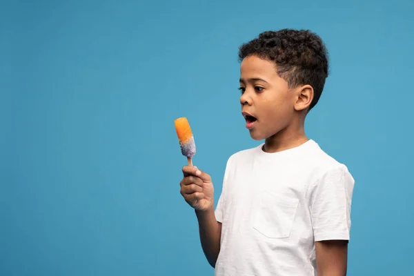 Carino Africano Bambino Bianco Shirt Guardando Arancione Gelato Mano Mentre — Foto Stock