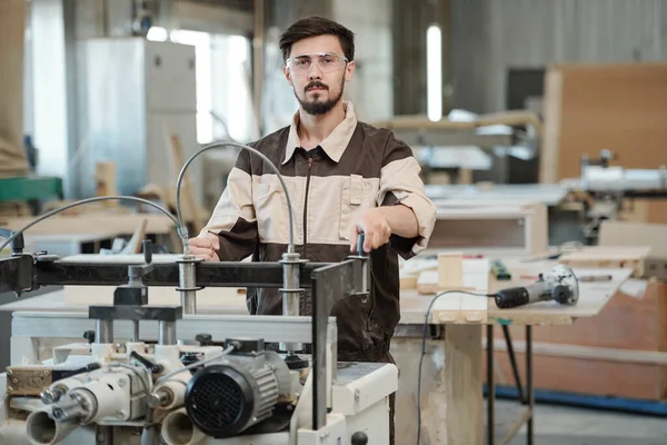 Jonge Serieuze Werknemer Van Meubelfabriek Die Naar Kijkt Terwijl Hij — Stockfoto