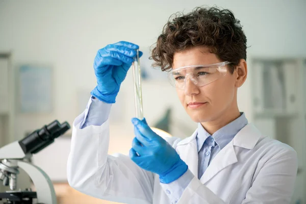 Focused Female Biologist Safety Goggles Protective Gloves Checking Test Tube — Stock Photo, Image