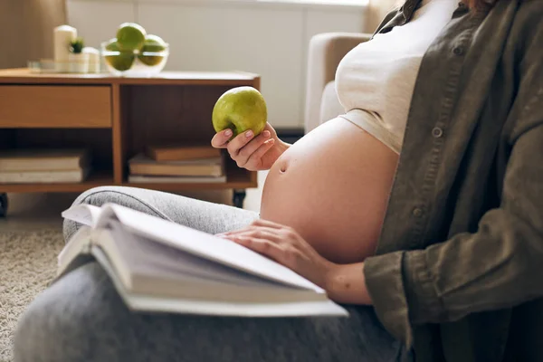 Jovem Mulher Grávida Relaxada Casualwear Comer Maçã Fresca Livro Leitura — Fotografia de Stock