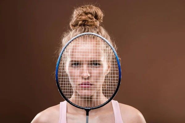 若いです深刻なスポーツ女性の顔とともにブロンド髪見ますあなたから後ろテニスラケットからカメラの前に立って — ストック写真