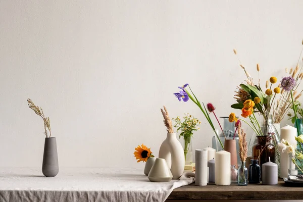 손으로 세라믹이나 항아리와 들꽃들이 양초들과 창조적 꽃병들이 식탁에 — 스톡 사진