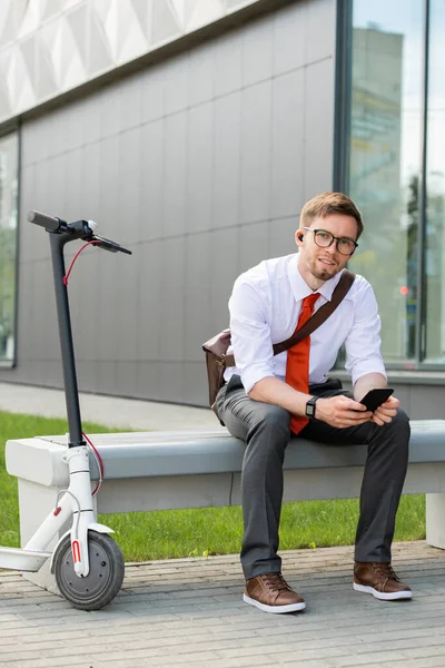 Vrolijke Jonge Rustgevende Zakenman Met Smartphone Zittend Bank Voor Camera — Stockfoto