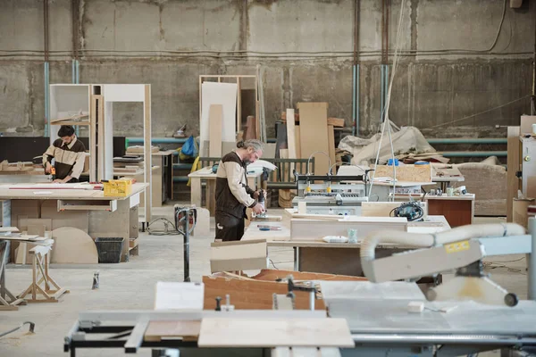 Два Работника Крупной Современной Мебельной Фабрики Стоящие Рабочих Скамеек Цехе — стоковое фото
