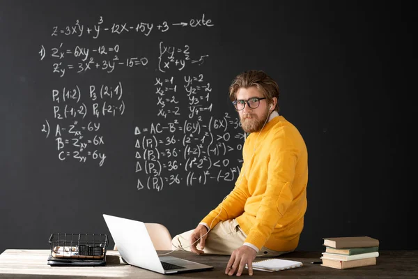 Joven Profesor Serio Con Auriculares Mirando Mientras Está Sentado Mesa — Foto de Stock