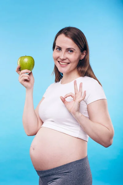 快乐健康的年轻孕妇 有绿色的苹果 给你展示一个健康的姿势 这意味着适当的营养很重要 — 图库照片