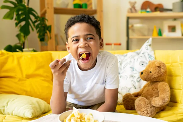 Joyful African Little Boy Shirt Putting Piece Food His Mouth — Stock Photo, Image