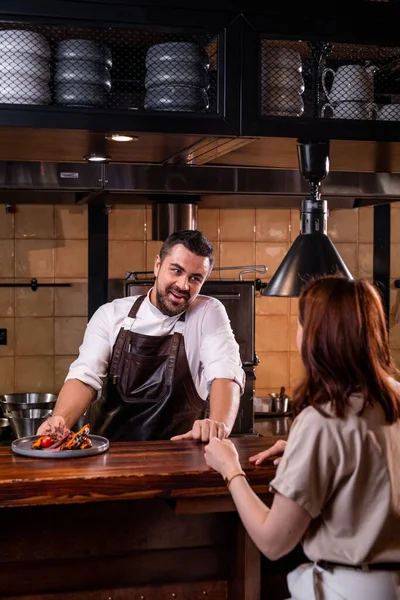 Bonito Chef Restaurante Avental Balcão Cozinha Aberta Contando Sobre Prato — Fotografia de Stock