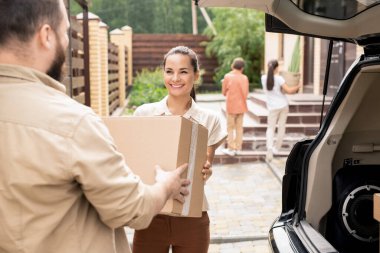 Yeni eve taşınırken yük vagonunu boşaltan adamın omuz üstü görüntüsü.